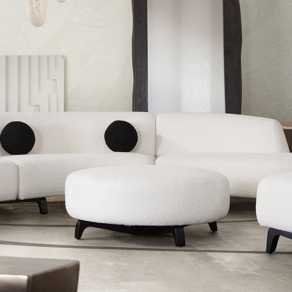 Vesper Round Ottoman in Faux White Shearling w/ Black Wood Leg Base by Diamond Sofa - styled in a staged room by Center Stage Home Design